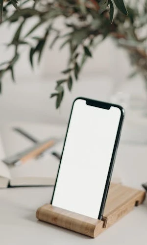 Smartphone with a blank screen and a plant in the background